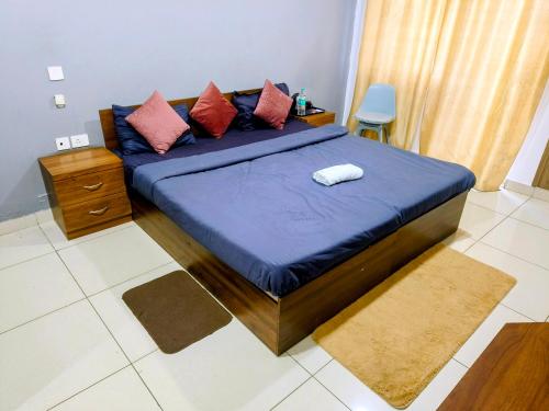a bedroom with a large blue bed with pillows at PLUTO HOMES in Greater Noida