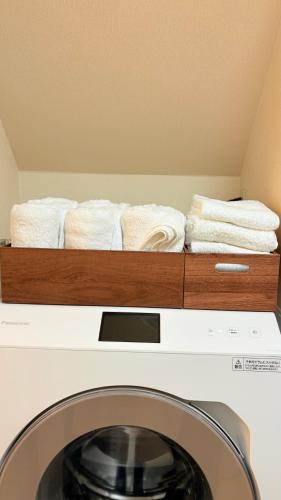 a pile of towels sitting on top of a washing machine at Phuong`s house in Kiso