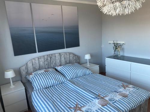 a bedroom with a bed with a striped comforter at Ferienwohnung Deichblick in Bremerhaven