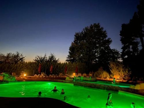 a group of people playing in a pool at night at ZEcamping 4 étoiles animaux acceptés tennis pataugeoire in Tamniès