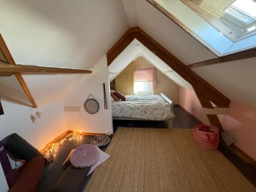 ein kleines Dachzimmer mit einem Bett und einem Fenster in der Unterkunft Slowflower in Ophemert