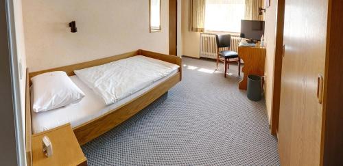 a bedroom with a bed and a desk with a computer at Hotel Keinath Stuttgart in Stuttgart