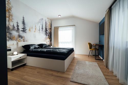 a bedroom with a bed and a painting on the wall at KNB City Suites in Odorheiu Secuiesc