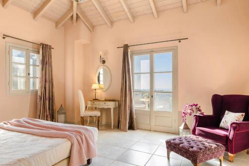 a bedroom with a bed and a chair and a window at Nikolas by Vintage Travel in Fiskardo