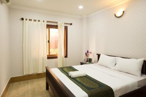 a bedroom with a white bed and white walls at RS Guesthouse in Phnom Penh