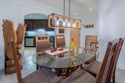 a dining room with a glass table and chairs at Magnifique condo 2 chambres in Beaupré