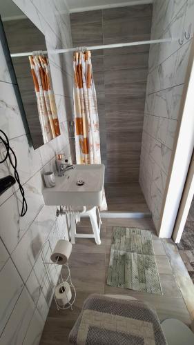 a bathroom with a sink and a shower at Antzela Apartments in Sidari