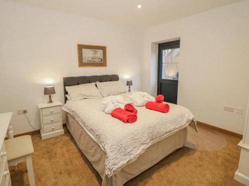 a bedroom with a bed with two red pillows on it at Courtyard View in Ashbourne