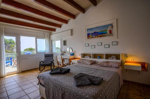 a bedroom with two beds and a table with a chair at Villa Sargantana Negra in Binibeca