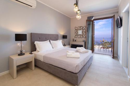 a bedroom with a bed with a view of the ocean at Vasilikades by Vintage Travel in Fiskardo