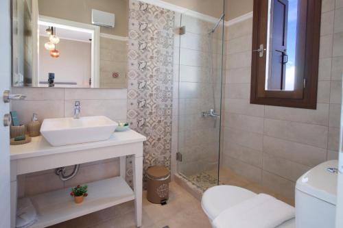 a bathroom with a sink and a shower at Vasilikades by Vintage Travel in Fiskardo