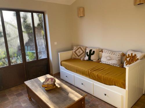 una camera da letto con un letto, un tavolo e una finestra di La Chateaude a Aubagne