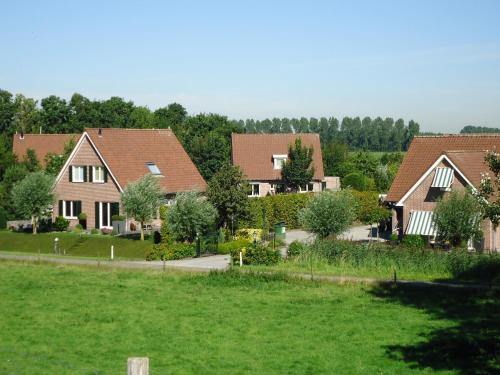 a group of houses in a green field at Huize Polderzicht aan het Grevelingenmeer in Battenoord