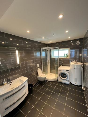 a bathroom with a sink and a washing machine at Nobelgården in Harstad