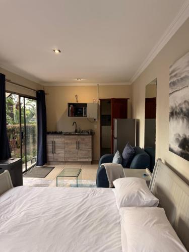 a bedroom with a bed and a living room at OneOnArum in Johannesburg