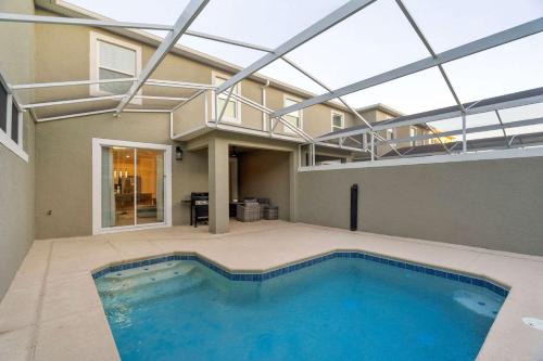 a swimming pool in a house with a large glass ceiling at Special 4bedroom TH w-private pool next to Disney in Kissimmee