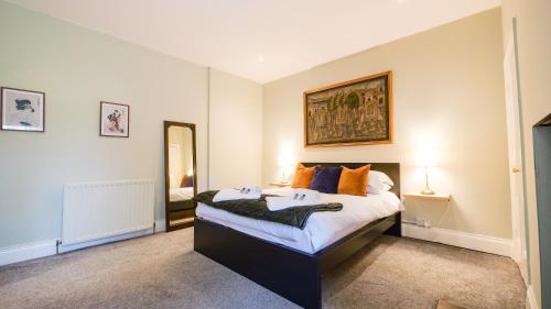 a bedroom with a large bed with orange pillows at Summers Nook in Humshaugh
