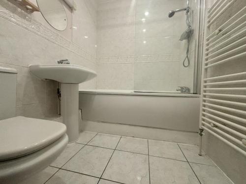 a bathroom with a sink and a toilet and a tub at Bracknell Spacious 2 Bedroom Apartment in Bracknell