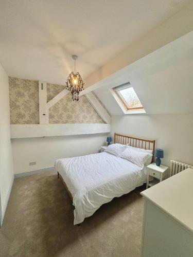a bedroom with a bed and a chandelier at Charming 2 bed cottage in Milcote Station