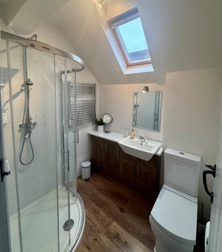 a bathroom with a shower and a toilet and a sink at Charming 2 bed cottage in Milcote Station