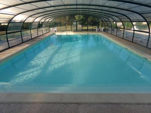 a large swimming pool in a greenhouse at Chalet 3 étoiles - Piscine - eebbhf in Beynat