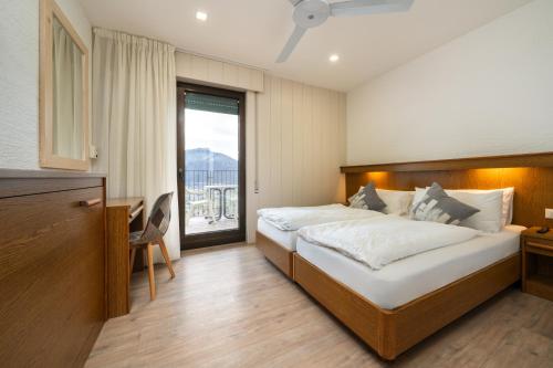 a bedroom with a large bed and a balcony at Hotel Deva in Riva del Garda