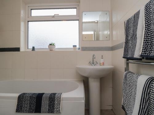 a bathroom with a sink and a bath tub and a window at Seabreeze in Filey
