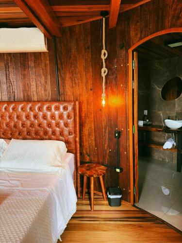 a bedroom with a bed and a chair and a sink at Pousada tanoeiro cabana Carvalho in Monte Belo