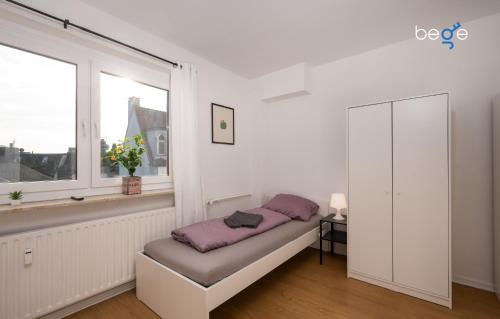 a white room with a bench in front of a window at BEGE APARTMENTS LoftWork in Lüdenscheid