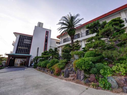 a building with a bunch of plants in front of it at Takumi Kanko Hotel in Minamichita