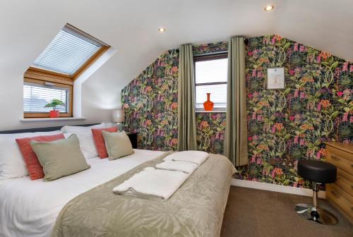 two beds in a bedroom with floral wallpaper at City Apartments - Reubens Court in York