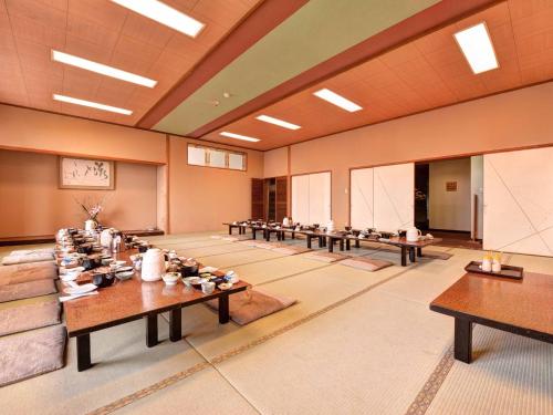 a large room with tables and chairs in it at Takumi Kanko Hotel in Minamichita