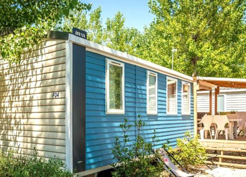 a blue tiny house in a yard at ZEcamping 4 étoiles animé piscine couverte club enfant mini golf dog friendly in La Faute-sur-Mer