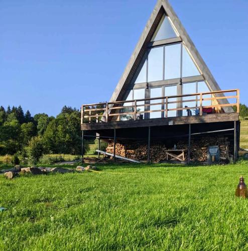 a building with a roof on top of a field at У Потічка in Izki