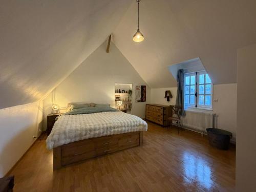 a bedroom with a large bed in a attic at Gite des Trévignes in Cambremer