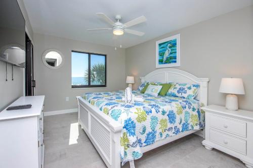a white bedroom with a bed and a window at Sandalfoot 5D3 - Oceanfront Sanibel Condo in Sanibel