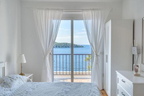 a bedroom with a bed and a view of the ocean at Apartments Lea in Prizba