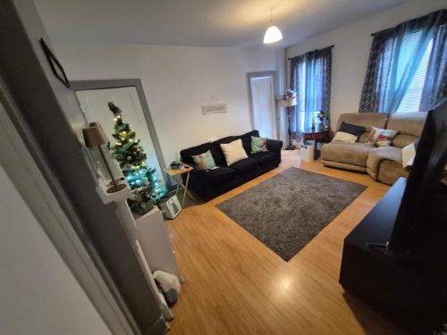 a living room with a christmas tree and a couch at Humble Beginning 47P in Norwich