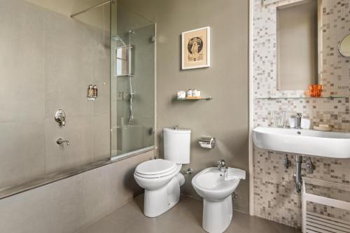 a bathroom with a toilet and a sink at Fontelunga Hotel & Villas in Pozzo