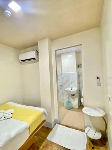 a room with a bed and a bathroom with a sink at RedDoorz at Urban Hotel in Zamboanga