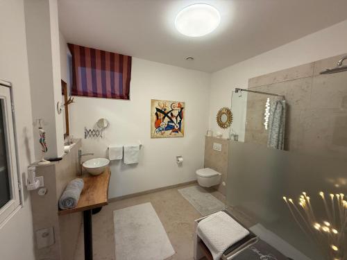 a bathroom with a sink and a toilet and a shower at Ferienwohnung Burgenblick mit Blick auf Riedenburg in Riedenburg