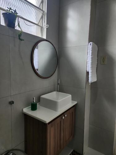 a bathroom with a sink and a mirror at Casa simples e funcional in Aimorés