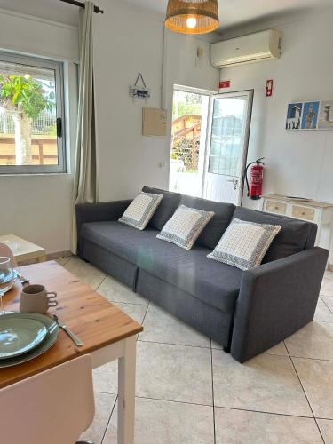 a black couch in a living room with a table at Casa João Bravo in Albufeira