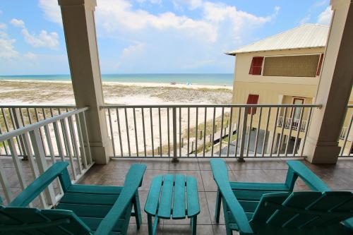 a balcony with chairs and a table and the beach at Summer Salt 4 West by Youngs Suncoast in Orange Beach