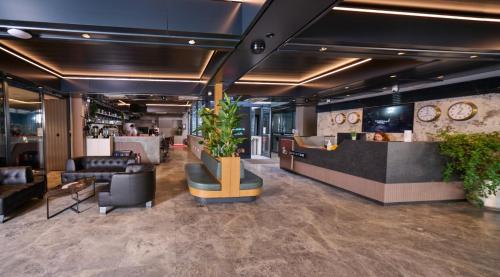 a lobby with a waiting area with plants and a counter at Livinton İstanbul Ataşehir in Istanbul