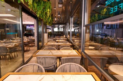 a restaurant with tables and chairs and windows at Livinton İstanbul Ataşehir in Istanbul