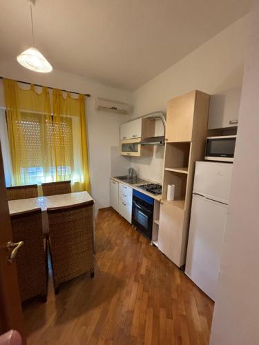 a small kitchen with white appliances and wooden floors at Casa Alighieri in Montalto Uffugo