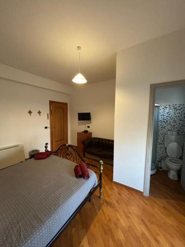 a bedroom with a bed and a bathroom with a toilet at Casa Alighieri in Montalto Uffugo