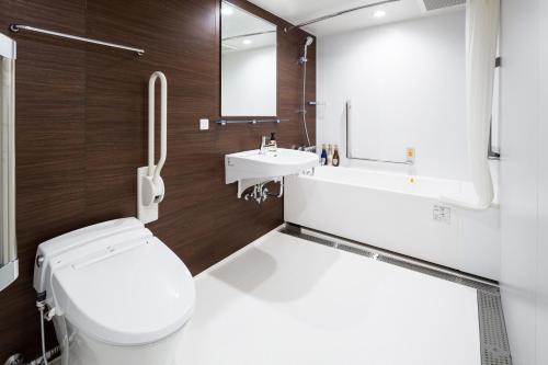 a bathroom with a toilet and a sink at HOTEL MYSTAYS Yokohama Kannai in Yokohama