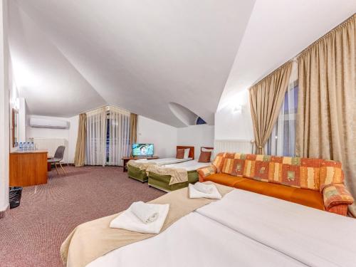 Hotel Elit في ديفين: غرفة فندقية بها ثلاثة أسرة وتلفزيون
